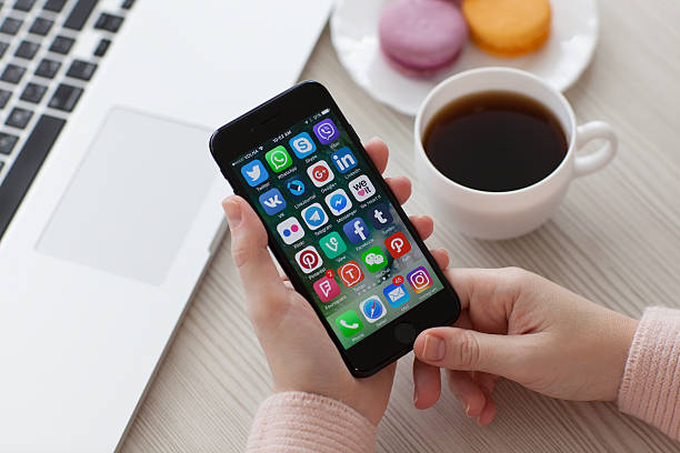 Alushta, Russia - November 19, 2016: A set of programs from famous brands of social networking on the iPhone 7 in woman hands. iPhone 7 Jet Black was created and developed by the Apple inc.